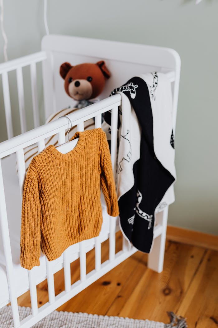 Home Charming baby room scene with knit sweater and teddy. Cozy and inviting.